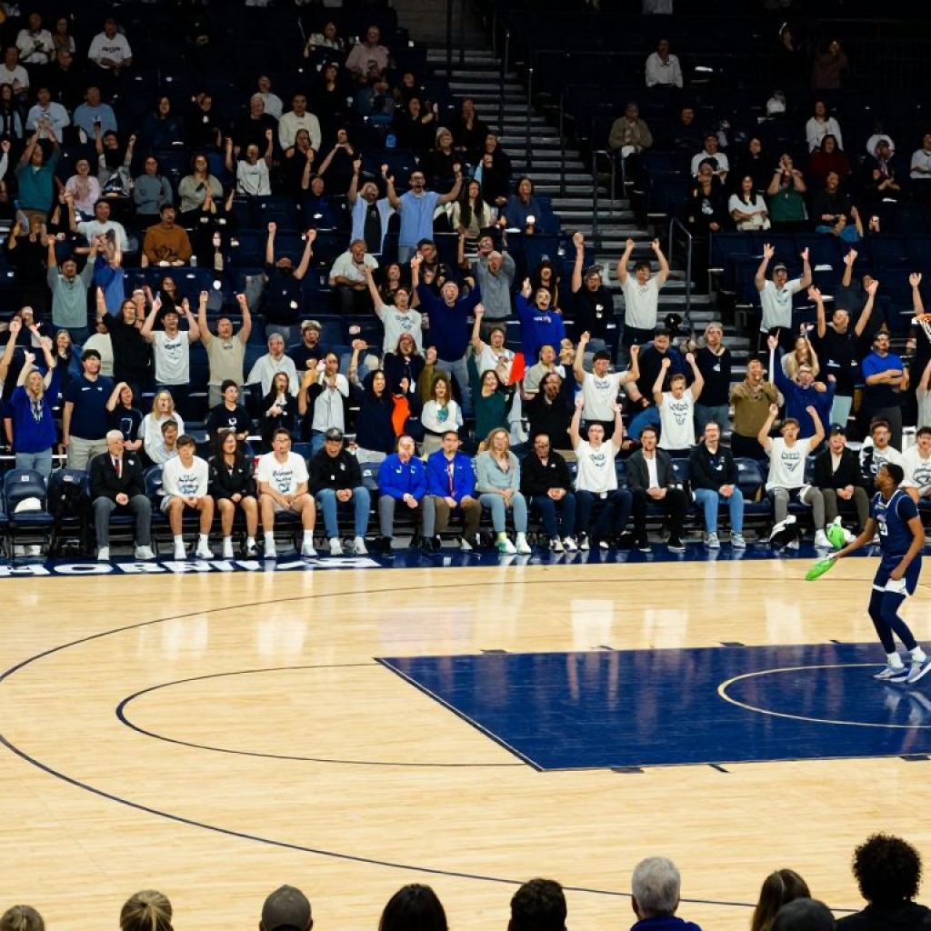 Basketball court featuring the Kansas City Roos logo and engaged fans.