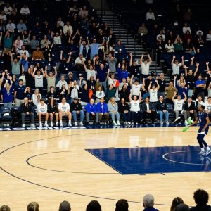Basketball court featuring the Kansas City Roos logo and engaged fans.