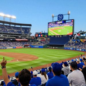 Fans enjoying a game at the stadium with Royals.TV backdrop